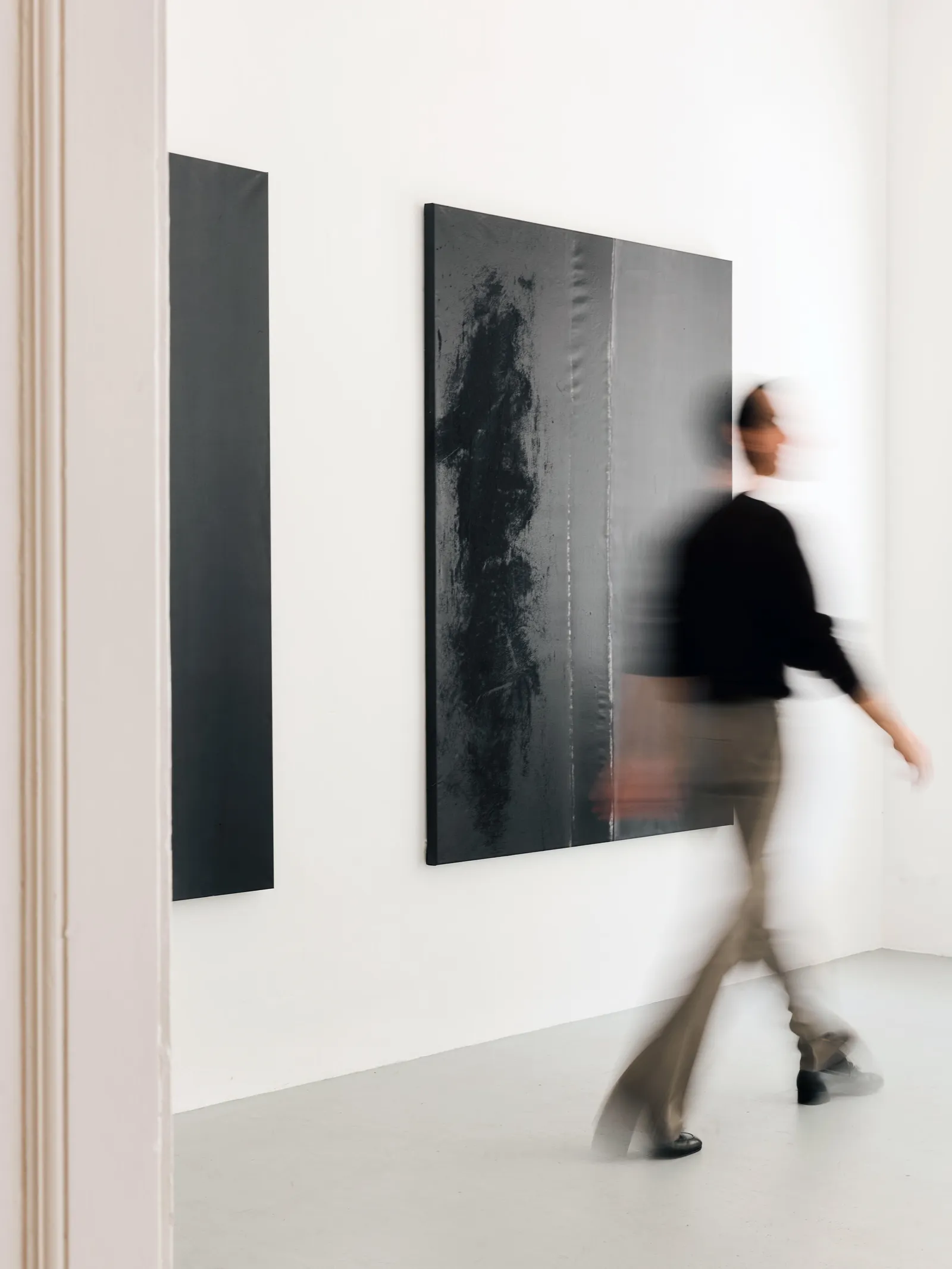 Visitor walking past paintings by FH Fischer in The Magic of Separation