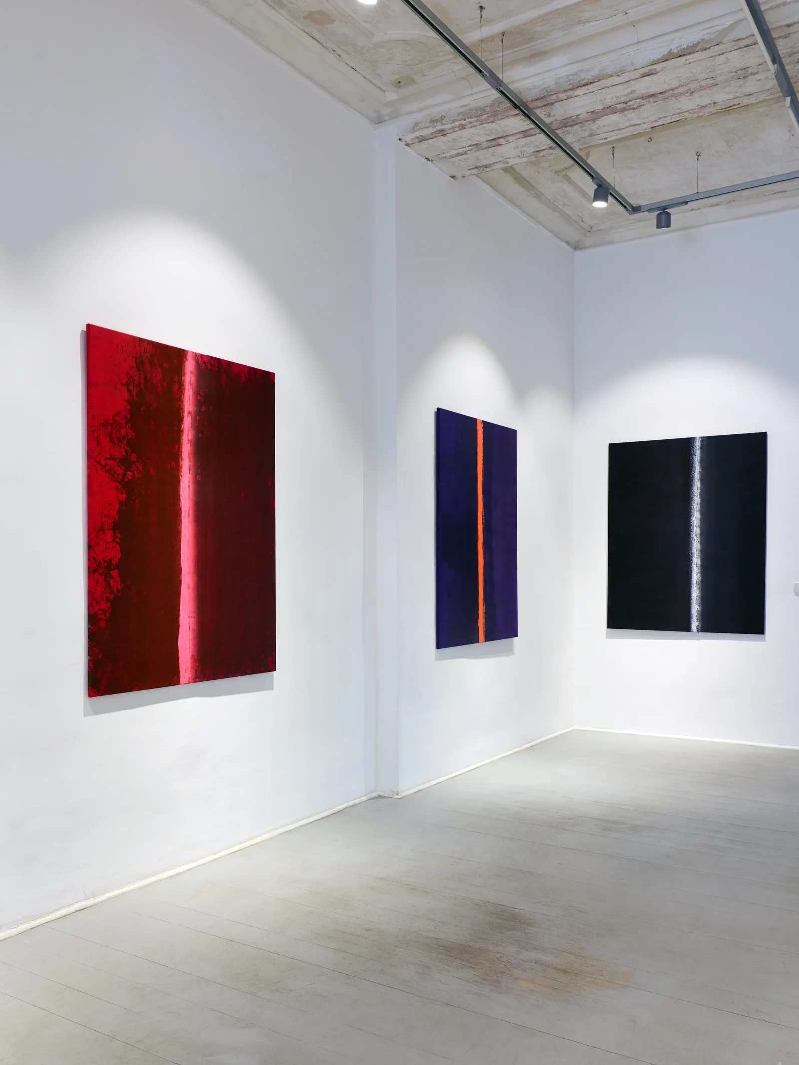 Red, blue and black paintings by FH Fischer installed in the gallery
